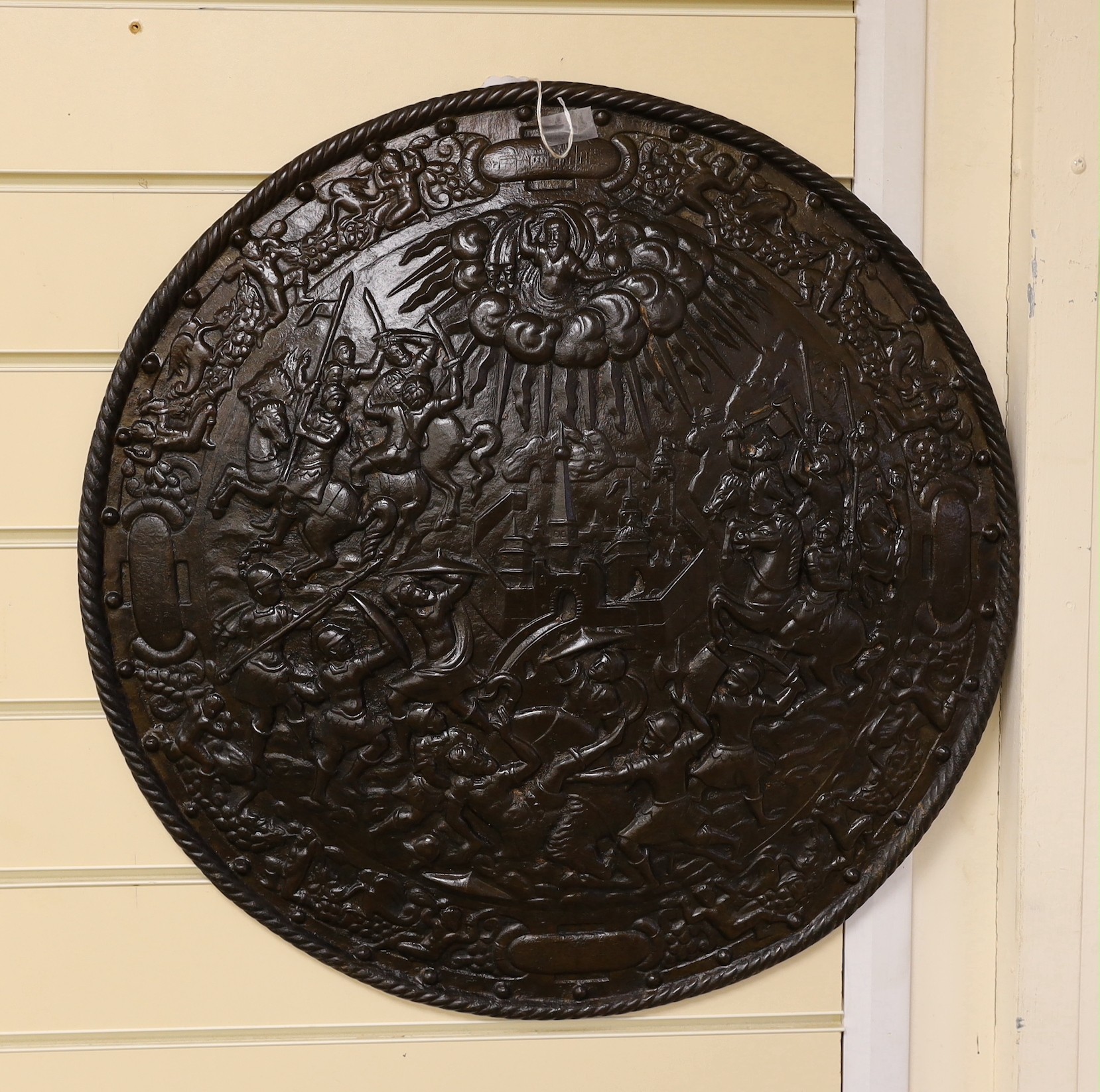 A Victorian cast iron shield shaped wall plaque, 55cms diameter.